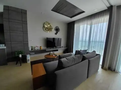 2 Bedroom Condo for Sale at Cetus Beachfront lounge area with TV wall and decorative floral accents