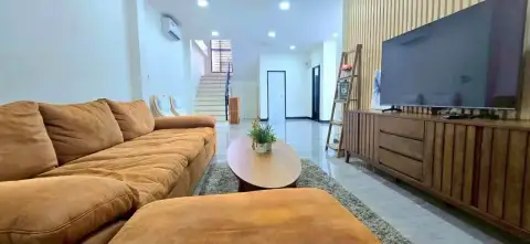 3 Bedroom House for Rent in Chak Nok open living area with sofa, staircase and large wall-mounted TV