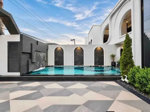 4 Bedroom House for Rent in Chak Nok glass-edge swimming pool beside modern white arched villa exterior