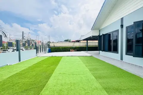 2 Bedroom House for Rent in Chak Nok backyard view with green lawn, patio, and gated entrance