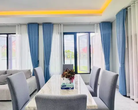 2 Bedroom House for Rent in Chak Nok bright dining area with marble table, grey chairs, and blue curtains