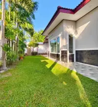3 Bedroom House for Rent in Chak Nok side garden with lush lawn and tiled walkway