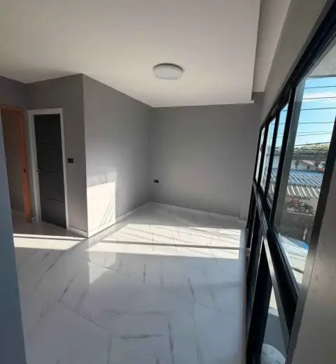 2 Bedroom Townhouse for Sale in Chak Nok sunlit corner room with tiled flooring and window view of rooftops