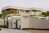 5 Bedroom House for Sale at Charin Pattaya entrance gate and signage with palm trees and curved architecture