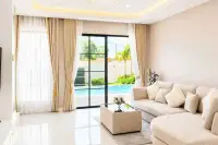 4 Bedroom House for Sale at Chokchai Garden Home 2, modern kitchen with white cabinets, island, stainless steel fridge, and bar.