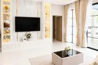 4 Bedroom House for Sale at Chokchai Garden Home 2, living room with a large L-shaped sofa, coffee table, and dining area.