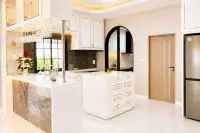 4 Bedroom House for Sale at Chokchai Garden Home 2, open-plan kitchen with white and gold cabinets, island, and dining area.