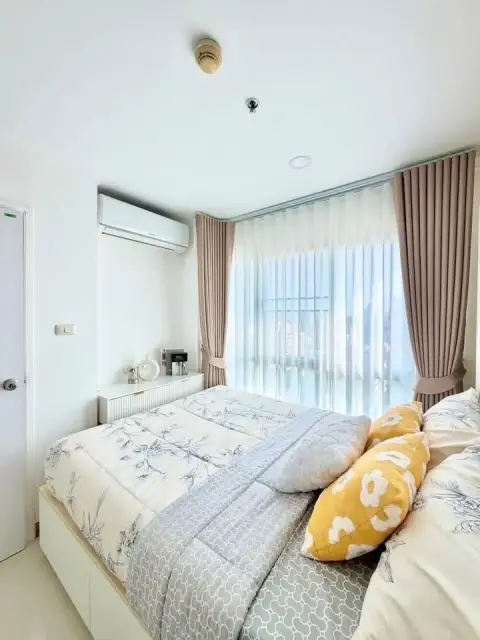 1 Bedroom Condo for Sale at City Center Residence bedroom with sheer curtains and wall-mounted air conditioner