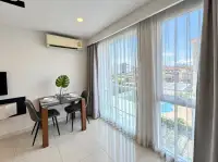 1 Bedroom Condo for Rent at City Center Residence dining area with city and pool view through sheer curtains