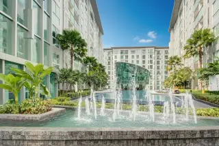 City Center Residence outdoor courtyard with fountains, palm trees, and modern apartment buildings.