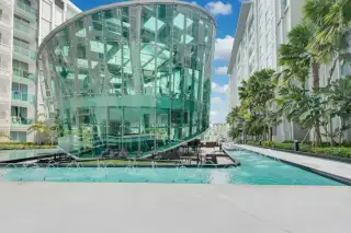 City Center Residence exterior view of a modern glass-domed building next to a decorative fountain.