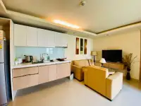 1 Bedroom Condo for Sale at City Garden Pattaya compact kitchen with white cabinets facing living area