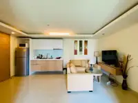 1 Bedroom Condo for Sale at City Garden Pattaya living room with sofa, TV console and kitchen view