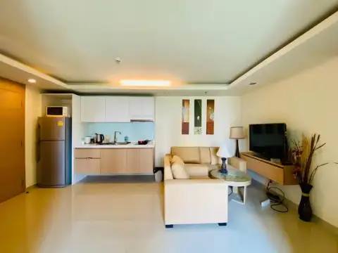 1 Bedroom Condo for Sale at City Garden Pattaya living room with sofa, TV console and kitchen view