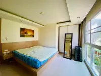 1 Bedroom Condo for Sale at City Garden Pattaya bedroom with platform bed, mirror and garden-view window