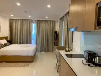 Studio Condo for Sale at City Garden Pratumnak open-plan layout with bed, dining table, and kitchenette