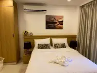 Studio Condo for Sale at City Garden Pratumnak wooden-framed bed with mountain artwork and bedside lamps