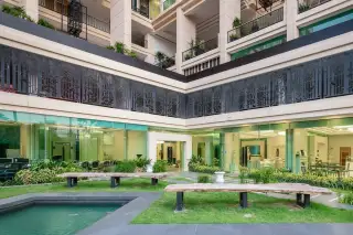 City Garden Tower poolside area with decorative checkered tiling, shallow water, and building exterior.