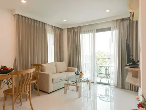 1 Bedroom Condo for Rent at City Garden Tropicana open living area with beige sofa and glass coffee table