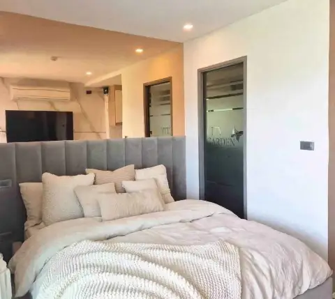 Studio Condo for Sale at City Garden Tropicana bedroom with upholstered headboard, TV and marble accent wall