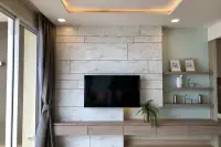 1 Bedroom Condo for Sale at Cetus Beachfront living room marble feature wall with flat-screen TV and cove ceiling lighting