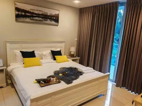 1 Bedroom Condo for Rent at Club Royal bedroom with white bed frame, yellow pillows and breakfast tray
