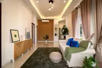3 Bedroom House for Sale at Coco Ville 2 Pong - Bang Lamung bright living room with white sofa, wood panel wall, and cove lighting