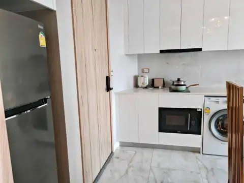 1 Bedroom Condo for Rent at Copacabana Beach Jomtien compact kitchenette with fridge, microwave, stovetop and washing machine