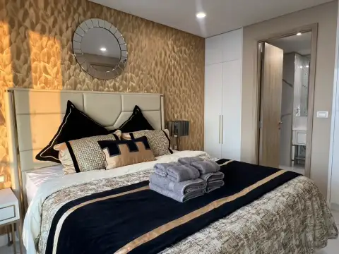1 Bedroom Condo for Rent at Copacabana Beach Jomtien bedroom with gold accent wall and round mirror