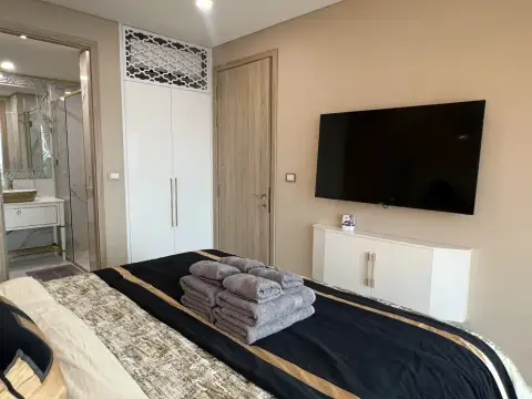 1 Bedroom Condo for Rent at Copacabana Beach Jomtien bedroom with wall-mounted TV and wardrobe