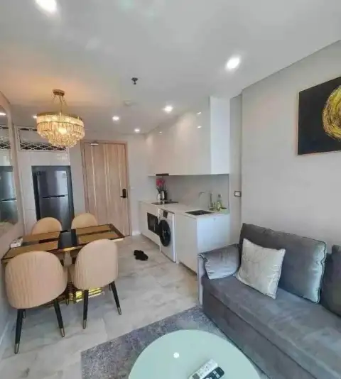 1 Bedroom Condo for Rent at Copacabana Beach Jomtien open-plan living room with kitchenette and gray sofa