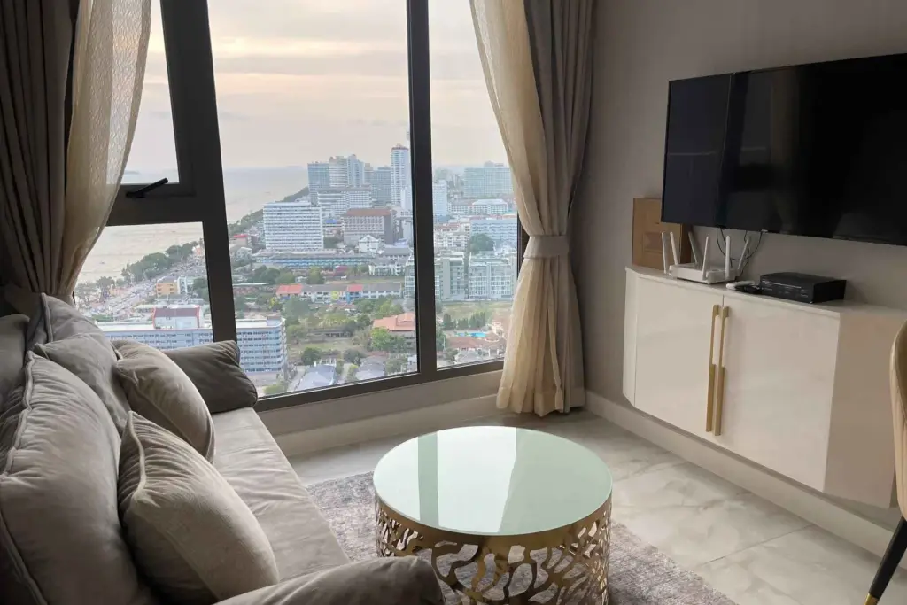 1 Bedroom Condo for Rent at Copacabana Beach Jomtien living room with sofa, TV and panoramic sea view