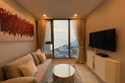1 Bedroom Condo for Rent at Copacabana Beach Jomtien lounge area with wall art, TV unit and ocean view window