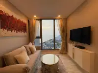 1 Bedroom Condo for Rent at Copacabana Beach Jomtien lounge area with wall art, TV and sea view at sunset