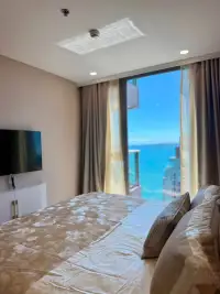 1 Bedroom Condo for Rent at Copacabana Beach Jomtien bedroom with king bed and floor-to-ceiling sea view window