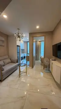1 Bedroom Condo for Rent at Copacabana Beach Jomtien living room with sofa, glass side table, TV, and view into bedroom