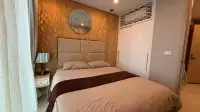 1 Bedroom Condo for Rent at Copacabana Beach Jomtien bedroom close-up with gold textured wall, round mirror, and white wardrobe