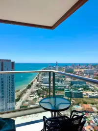 1 Bedroom Condo for Rent at Copacabana Beach Jomtien high-rise balcony with table and panoramic Jomtien beach view