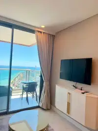 1 Bedroom Condo for Rent at Copacabana Beach Jomtien wall-mounted TV with ocean view through balcony door