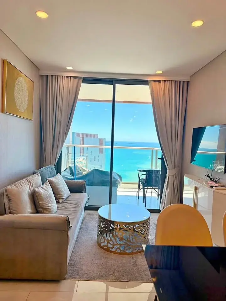 1 Bedroom Condo for Rent at Copacabana Beach Jomtien living room with gray sofa and panoramic sea view balcony