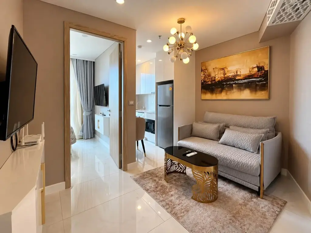 1 Bedroom Condo for Rent at Copacabana Beach Jomtien living room with gray sofa, gold coffee table and TV