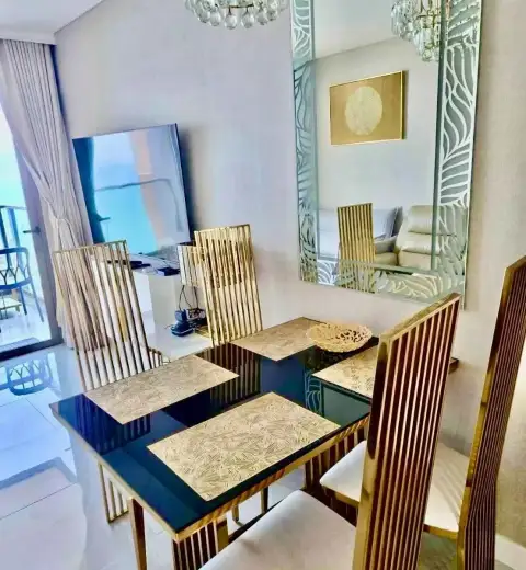 1 Bedroom Condo for Rent at Copacabana Beach Jomtien dining table with gold-framed chairs and decorative wall mirror