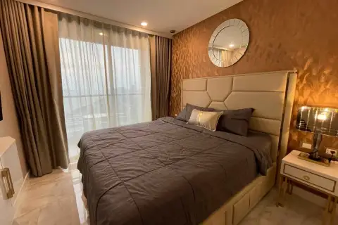 1 Bedroom Condo for Rent at Copacabana Beach Jomtien bedroom with upholstered headboard and round mirror
