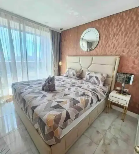 1 Bedroom Condo for Rent at Copacabana Beach Jomtien bedroom with patterned bedspread and round mirror