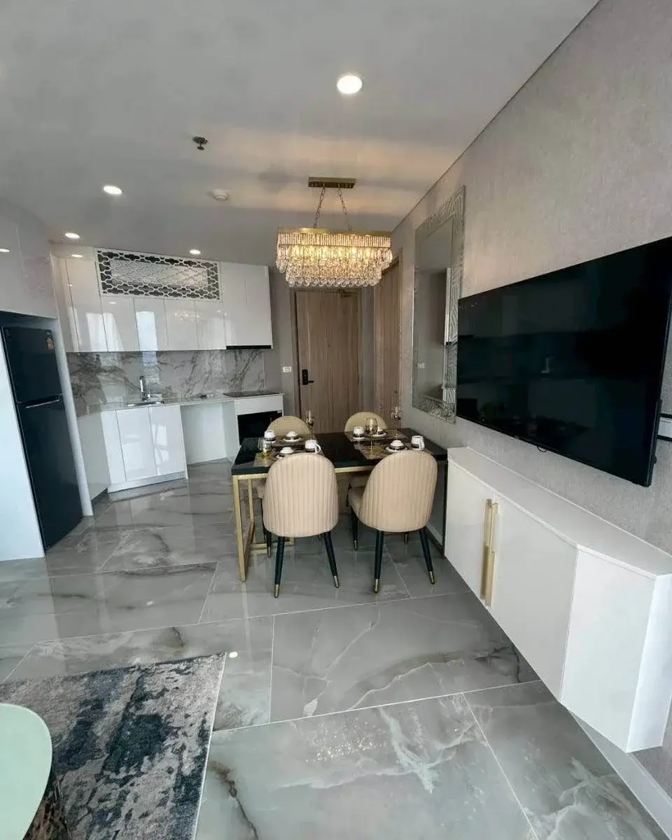 1 Bedroom Condo for Rent at Copacabana Beach Jomtien dining area with crystal chandelier and wall-mounted TV