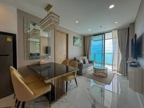 2 Bedroom Condo for Rent at Copacabana Beach Jomtien open-plan dining area with ocean view and gold chairs