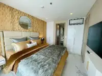 1 Bedroom Condo for Sale at Copacabana Beach Jomtien bedroom with faux fur throw, built-in wardrobes, and marble flooring