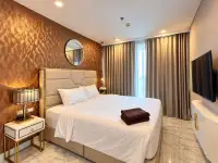 1 Bedroom Condo for Sale at Copacabana Beach Jomtien bedroom with white bedding, bronze accent wall and round mirror