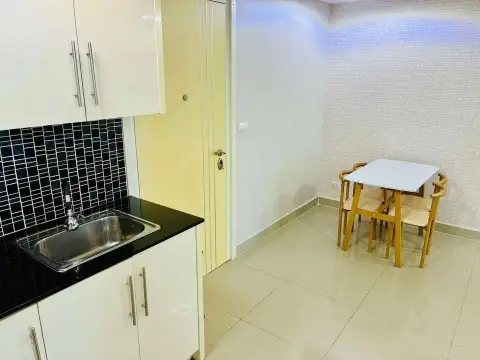 1 Bedroom Condo for Sale at Cosy Beach View compact kitchenette with black countertop and small dining table