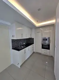 1 Bedroom Condo for Sale at Cosy Beach View modern kitchen with white cabinets and built-in oven